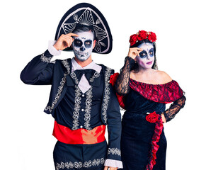 Poster - Young couple wearing mexican day of the dead costume over background worried and stressed about a problem with hand on forehead, nervous and anxious for crisis