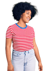 Sticker - Young african american girl wearing casual clothes looking away to side with smile on face, natural expression. laughing confident.