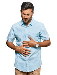 Sticker - Handsome hispanic man wearing casual clothes with hand on stomach because indigestion, painful illness feeling unwell. ache concept.