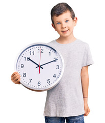 Poster - Cute blond kid holding big clock looking positive and happy standing and smiling with a confident smile showing teeth