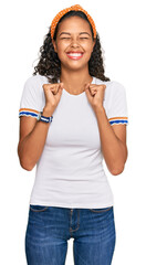 Wall Mural - Young african american girl wearing casual clothes excited for success with arms raised and eyes closed celebrating victory smiling. winner concept.