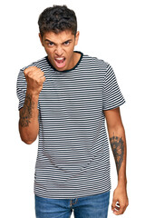 Wall Mural - Young handsome african american man wearing casual clothes angry and mad raising fist frustrated and furious while shouting with anger. rage and aggressive concept.