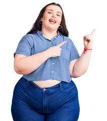 Wall Mural - Young plus size woman wearing casual clothes smiling and looking at the camera pointing with two hands and fingers to the side.