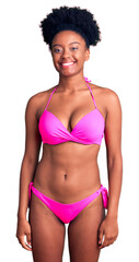 Poster - Young african american woman wearing bikini looking positive and happy standing and smiling with a confident smile showing teeth