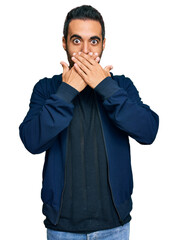 Canvas Print - Young hispanic man wearing casual clothes shocked covering mouth with hands for mistake. secret concept.