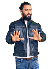Young arab man wearing casual leather jacket moving away hands palms showing refusal and denial with afraid and disgusting expression. stop and forbidden.