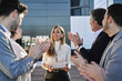 © Oscar - group of businessmen at a meeting or business plan exhibition applauding a middle-aged woman who was the event's sponsor