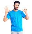 © Krakenimages.com - Young handsome man with beard wearing casual t-shirt showing and pointing up with fingers number six while smiling confident and happy.
