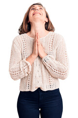 Wall Mural - Young beautiful blonde woman wearing casual sweater begging and praying with hands together with hope expression on face very emotional and worried. begging.