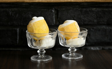 Ice cream sorbet in lemon and glass on dark background