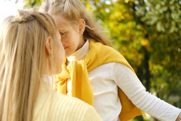 Close up of happy mother and daughter smiling, touching with foreheads