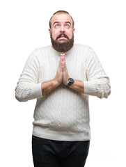 Poster - Young caucasian hipster man wearing winter sweater over isolated background begging and praying with hands together with hope expression on face very emotional and worried. Asking for forgiveness