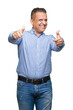 © Krakenimages.com - Middle age arab business man over isolated background approving doing positive gesture with hand, thumbs up smiling and happy for success. Looking at the camera, winner gesture.