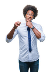 Sticker - Afro american man holding visit card over isolated background serious face thinking about question, very confused idea