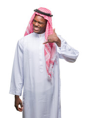 Poster - Young arabic african man wearing traditional keffiyeh over isolated background smiling doing phone gesture with hand and fingers like talking on the telephone. Communicating concepts.