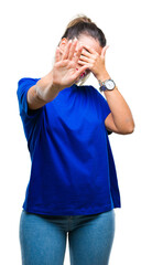 Wall Mural - Young beautiful woman wearing casual blue t-shirt over isolated background covering eyes with hands and doing stop gesture with sad and fear expression. Embarrassed and negative concept.