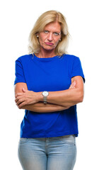 Sticker - Middle age blonde woman over isolated background skeptic and nervous, disapproving expression on face with crossed arms. Negative person.