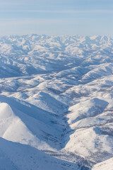 Wall Mural - aerial view of snow-capped mountains. winter snowy mountain landscape. air travel to the far north o