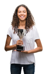 Canvas Print - Young hispanic woman holding trophy with a happy face standing and smiling with a confident smile showing teeth