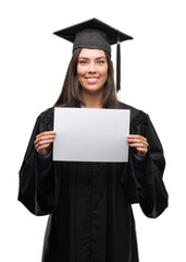 Poster - Young hispanic woman wearing graduated uniform holding diploma paper with a happy face standing and smiling with a confident smile showing teeth