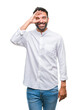 © Krakenimages.com - Adult hispanic man over isolated background doing ok gesture with hand smiling, eye looking through fingers with happy face.