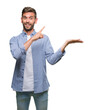© Krakenimages.com - Young handsome man wearing white t-shirt over isolated background amazed and smiling to the camera while presenting with hand and pointing with finger.