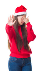 Canvas Print - Young Chinese woman over isolated background wearing christmas hat covering eyes with hands and doing stop gesture with sad and fear expression. Embarrassed and negative concept.