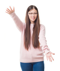 Wall Mural - Young Chinese woman over isolated background wearing glasses looking at the camera smiling with open arms for hug. Cheerful expression embracing happiness.