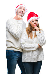 Sticker - Middle age hispanic couple wearing christmas hat over isolated background with hand on chin thinking about question, pensive expression. Smiling with thoughtful face. Doubt concept.