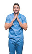 © Krakenimages.com - Handsome young doctor surgeon man over isolated background praying with hands together asking for forgiveness smiling confident.