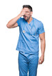 © Krakenimages.com - Handsome young doctor surgeon man over isolated background peeking in shock covering face and eyes with hand, looking through fingers with embarrassed expression.