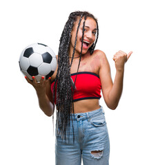 Sticker - Young braided hair african american with birth mark holding soccer ball over isolated background pointing and showing with thumb up to the side with happy face smiling