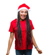 © Krakenimages.com - Young braided hair african american girl wearing christmas hat over isolated background with a happy and cool smile on face. Lucky person.