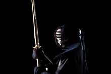 Side View Of Person Playing Fencing Against Dark Background