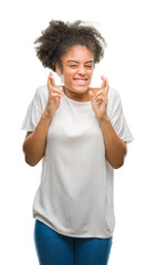 Sticker - Young afro american woman over isolated background smiling crossing fingers with hope and eyes closed. Luck and superstitious concept.