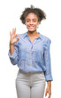 © Krakenimages.com - Young afro american woman over isolated background smiling positive doing ok sign with hand and fingers. Successful expression.