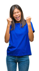 Poster - Young asian woman over isolated background very happy and excited doing winner gesture with arms raised, smiling and screaming for success. Celebration concept.