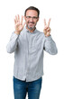 © Krakenimages.com - Handsome middle age elegant senior man wearing glasses over isolated background showing and pointing up with fingers number seven while smiling confident and happy.