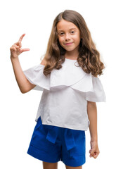 Sticker - Brunette hispanic girl smiling and confident gesturing with hand doing size sign with fingers while looking and the camera. Measure concept.