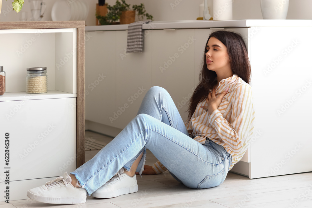 Young woman having panic attack in kitchen