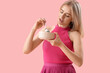 © Pixel-Shot - Young woman with spoon and bowl on pink background