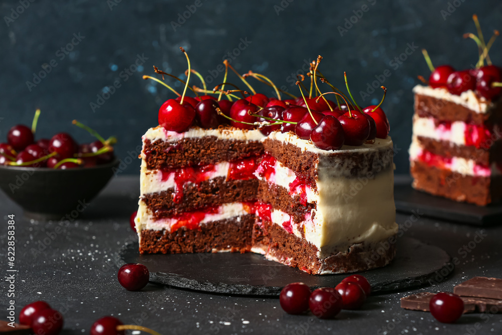 Tasty cherry cake and board with piece on black table