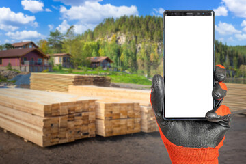 Poster - Phone in builder hand. Smartphone mock up. Construction site with logs. Place for building offer. Phone with white screen. Country house construction. Copy space on white. Construction company phone
