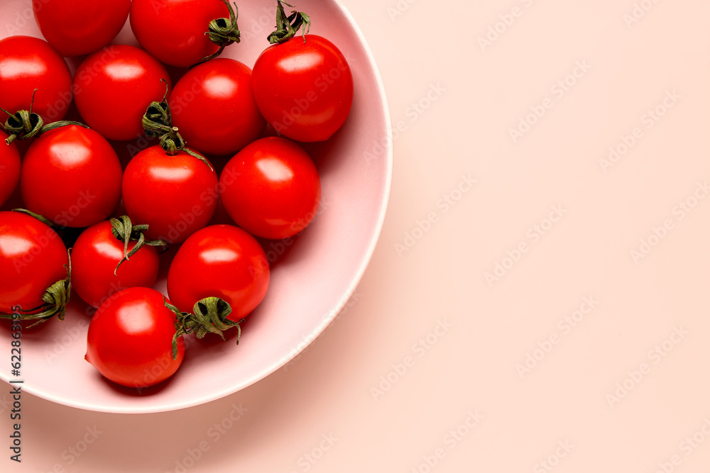 Bowl with fresh cherry tomatoes on pink background