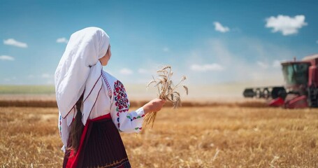 Wall Mural - Girl in traditional ethnic folklore costume with Bulgarian embroidery standing on a harvest golden wheat field, Agriculture, agronomy Bulgaria