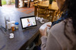© Wavebreak Media - Biracial woman sitting at countertop, using tablet for medical consultation with biracial doctor