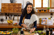 © Wavebreak Media - Portrait of happy biracial woman wearing apron cooking dinner, chopping vegetables in kitchen