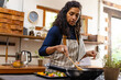 © Wavebreak Media - Biracial woman wearing apron cooking dinner in kitchen