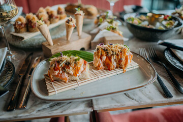 Wall Mural - Close up of culinary food plate with filled table full of food and drinks in restaurant