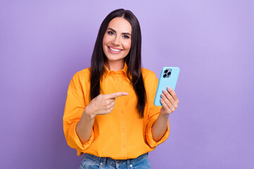 Poster - Photo of cheerful girl yellow shirt directing at smartphone instagram telegram facebook twitter isolated on purple color background